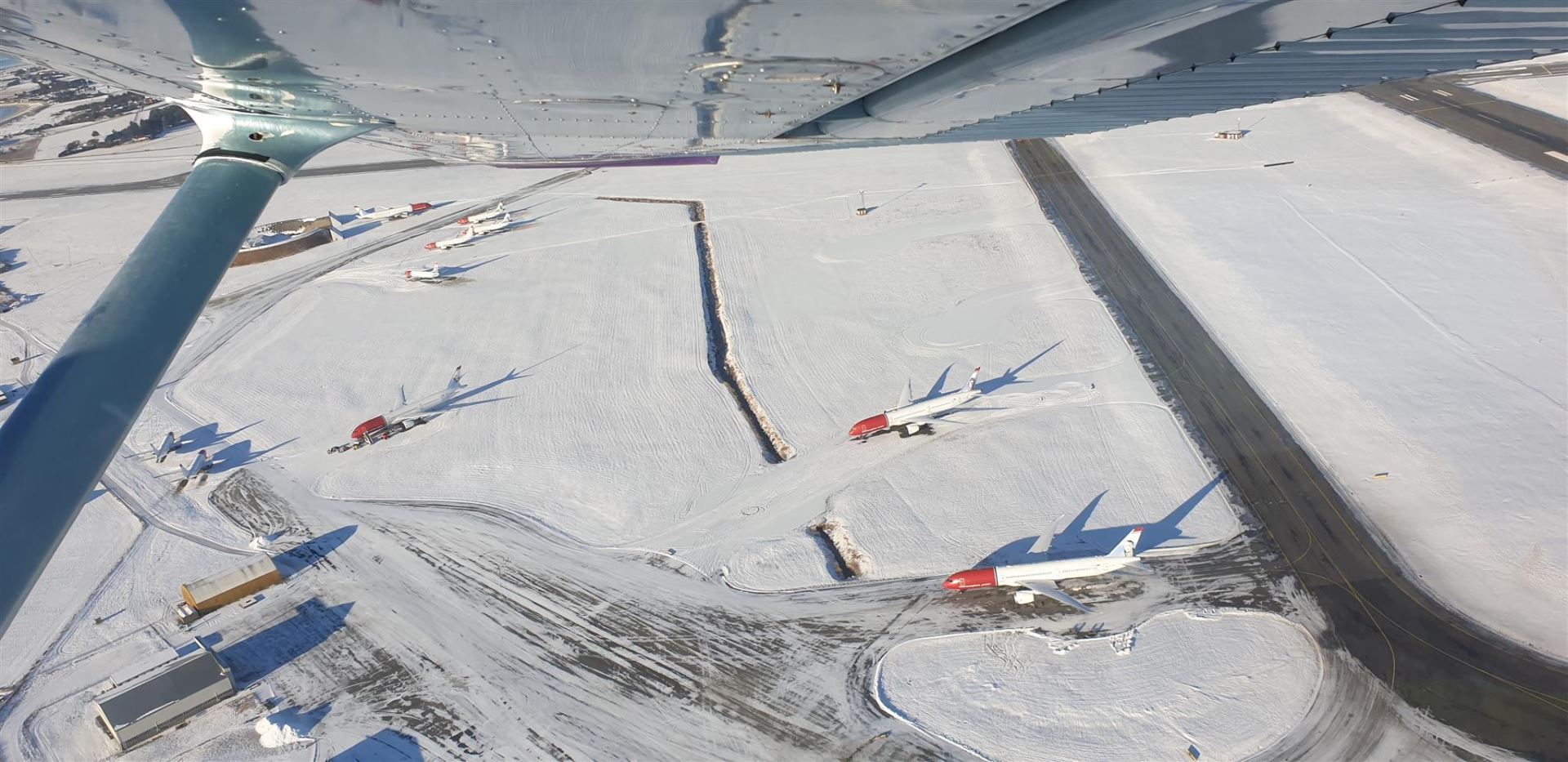 Departing overhead all the parked Norwegian airplanes